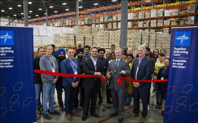 Photo of people standing behind ribbon during a ribbon-cutting ceremony.