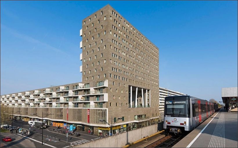 Photo of apartment building next to a train in Amsterdam.