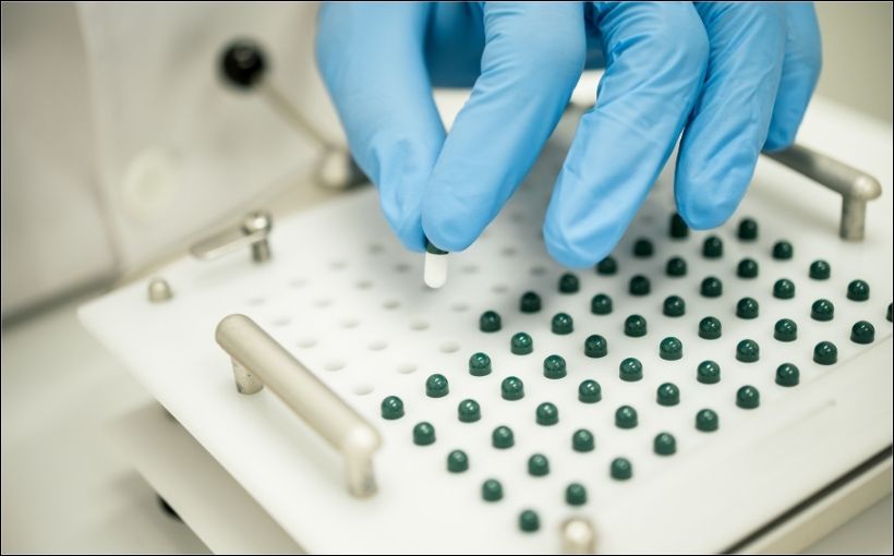 Photo of hand and test tubes.